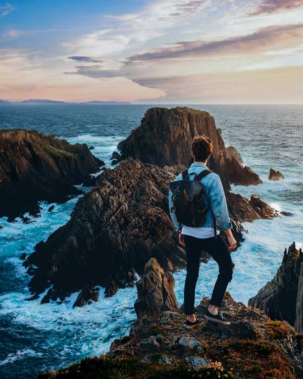 A traveler is standing by the ocean. Mistakes To Avoid When Traveling Alone